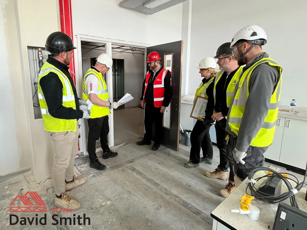 Men in hard hats and hi vis jackets on building site