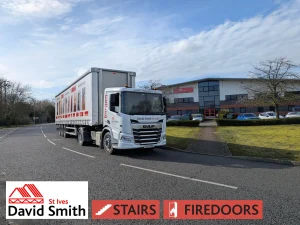 White lorry covered in DSSI imagery and branding on a road on a sunny day.
