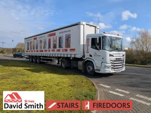 White lorry covered in DSSI imagery and branding on a road on a sunny day.